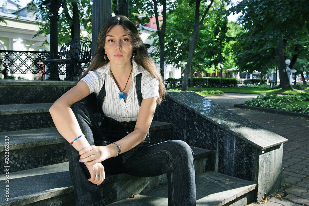 The girl sits in park on steps The girl sits in park on steps