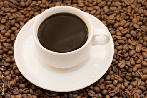 White coffee cup filled with coffee beans