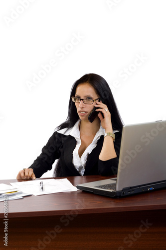 woman working with laptop holding phone