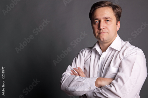 Portrait of the man in a white shirt on a dark grey background