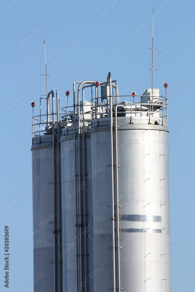 Tall metal silos for storing grain against a blue sky