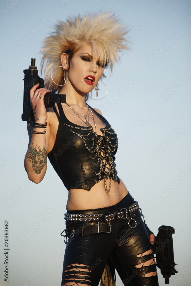 A sexy punk rocker woman with two automatic pistols. Stock Photo
