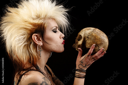 A sexy punk rocker woman holding a human skull.