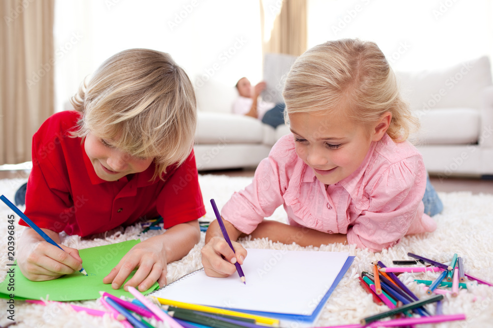 Concentrated children drawing lying on the floor Concentrated children drawing lying on the floor