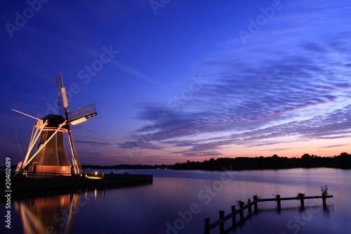 Dutch sunset with windmill at a lake.