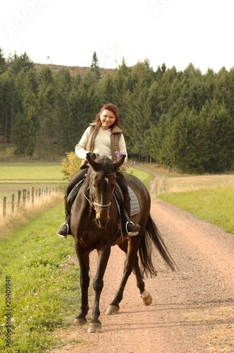 Horsewoman on tittup horse on country roads.
