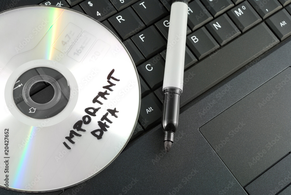 Important data disk on laptop keyboard concept. Important data disk on laptop keyboard concept.