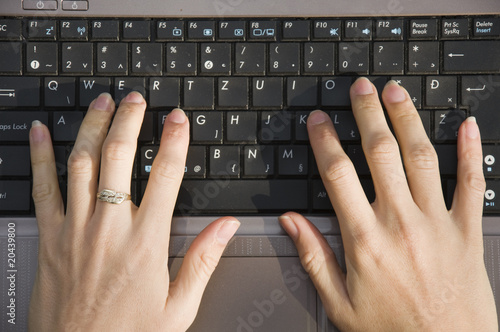 Closeup of female fingers typing on the laptop