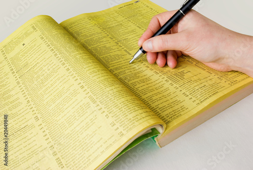 Search yellow pages with hand and pen