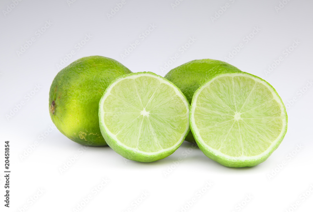 four lime fruit on gray background four lime fruit on gray background