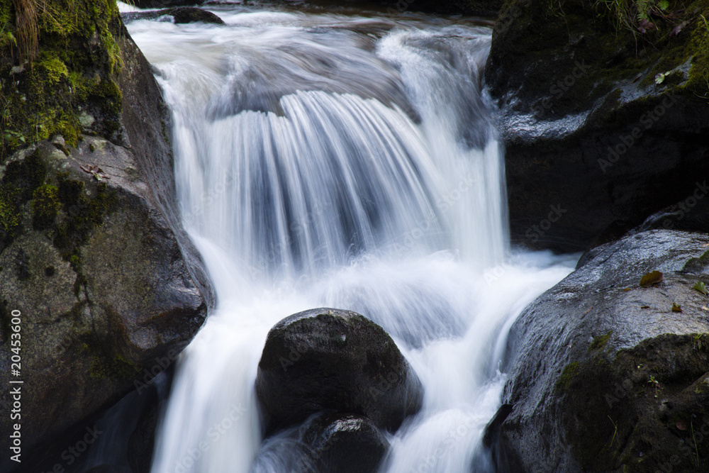 Bach mit fließendem Wasser und Steinen (Felsen) Bach mit fließendem Wasser und Steinen (Felsen)