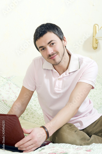 young handsome man working online from his house on laptop