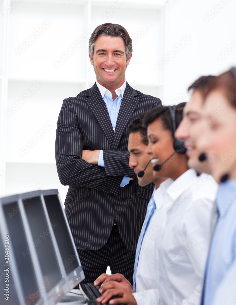 Self-assured businessman presenting a call center Self-assured businessman presenting a call center