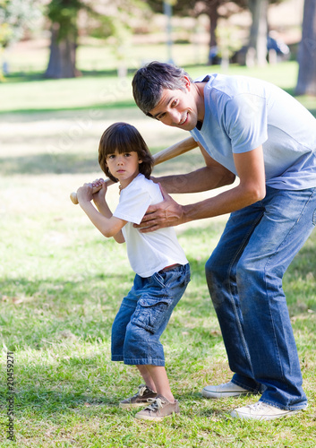 Smiling father teaching baseball to his son