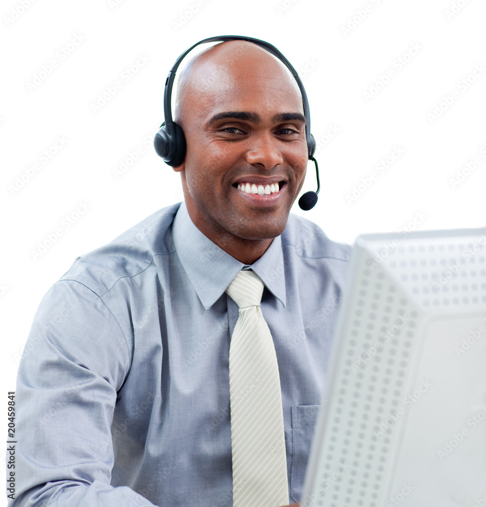 Happy businessman talking on headset at a computer Happy businessman talking on headset at a computer