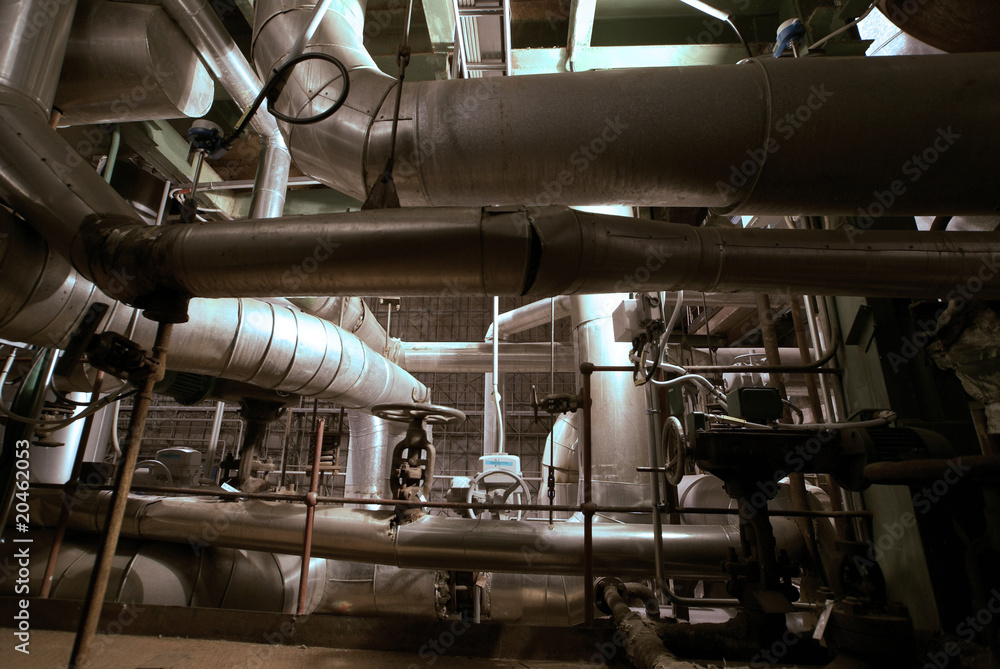 Equipment, cables and piping as found inside of a modern industr