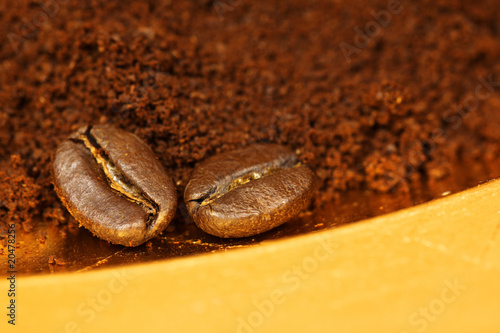 Two coffee beans and ground coffee