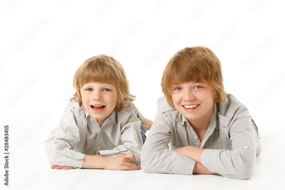 Two Young Boys Lying On Stomach In Studio Two Young Boys Lying On Stomach In Studio