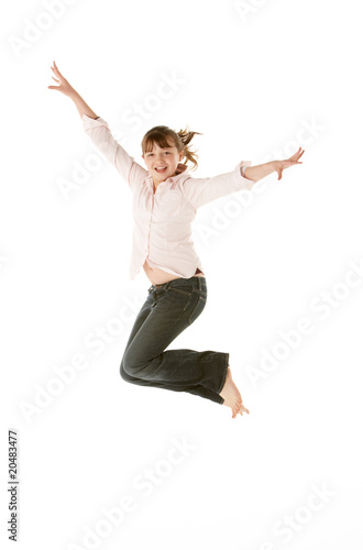 Studio Shot Of Young Girl Jumping In Studio