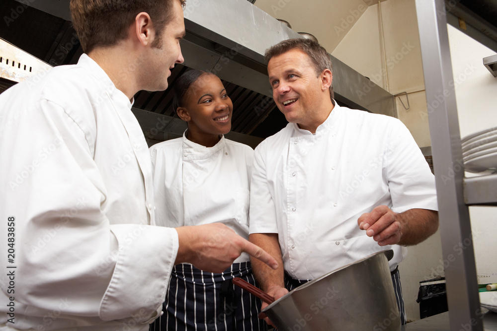 Obraz premium Chef Instructing Trainees In Restaurant Kitchen