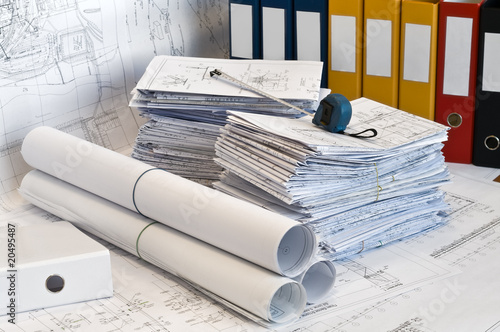 Heap of design and project drawings in yellow folder.
