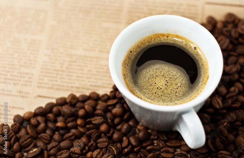 Cup and Coffee Beans on newspaper backgroun Cup and Coffee Beans on newspaper backgroun