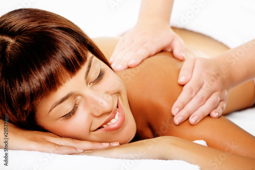 Close-up of a beautiful smiling woman getting a massage.
