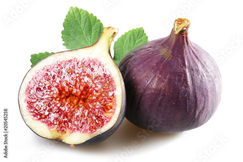 Figs with cut fruit and leaves on a white background