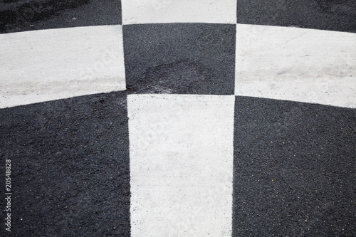 Geometrical white lines painted on black asphalt