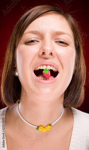 Real beautiful young woman with raspberry in lips