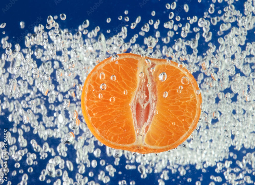Orange (mandarin) floating in blue water