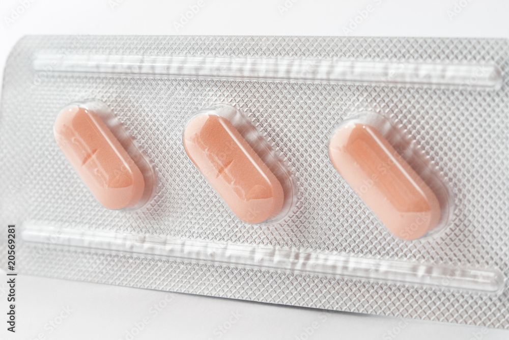 Closeup of a pack of three orange pills with selective focus Closeup of a pack of three orange pills with selective focus