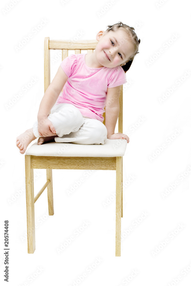 Adorable six year old girl sitting on a pine chair. Adorable six year old girl sitting on a pine chair.