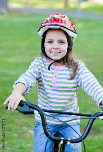 Joyful little girl riding a bike