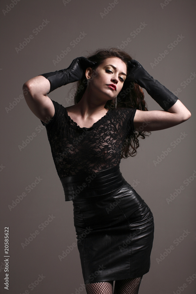 beautiful sexy young woman wearing a leather skirt and gloves