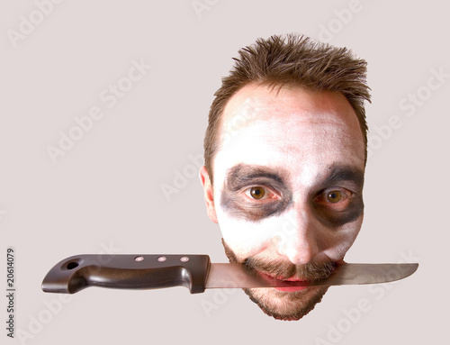 tête d'un homme le couteau entre les dents