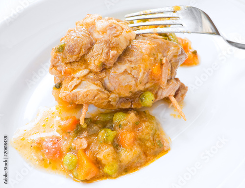 Meat roulade with vegetable soup on white dish.