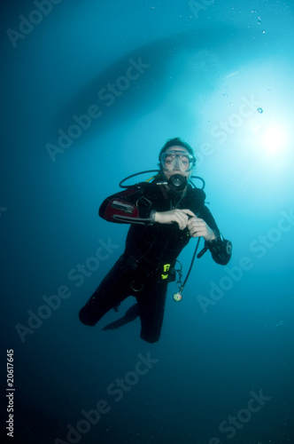 woman scuba diver swimming in clear blue water © JonMilnes