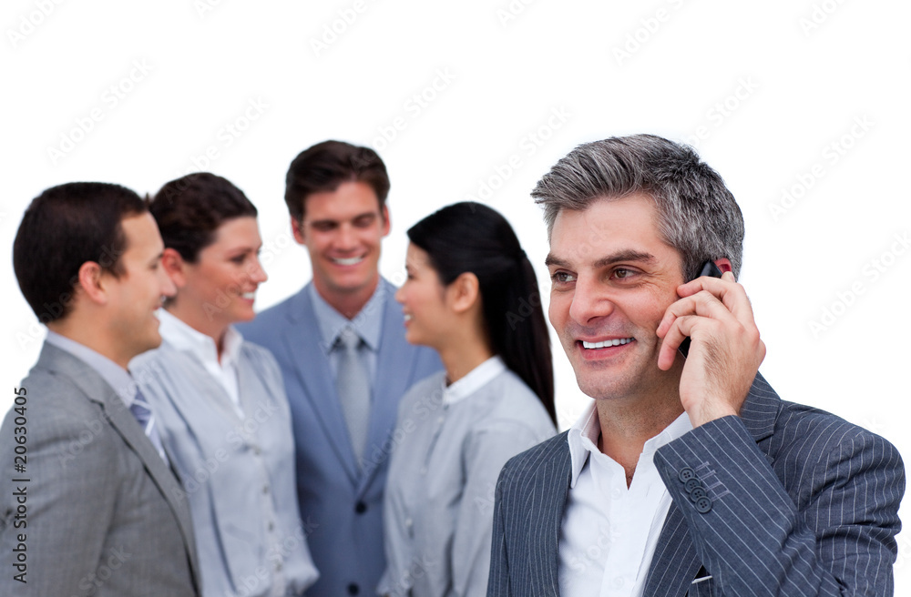 Confident mature manager on phone standig in front of his team Confident mature manager on phone standig in front of his team