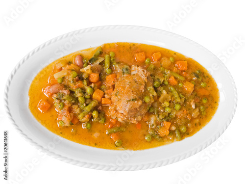Meat roulade with vegetable soup on white dish.
