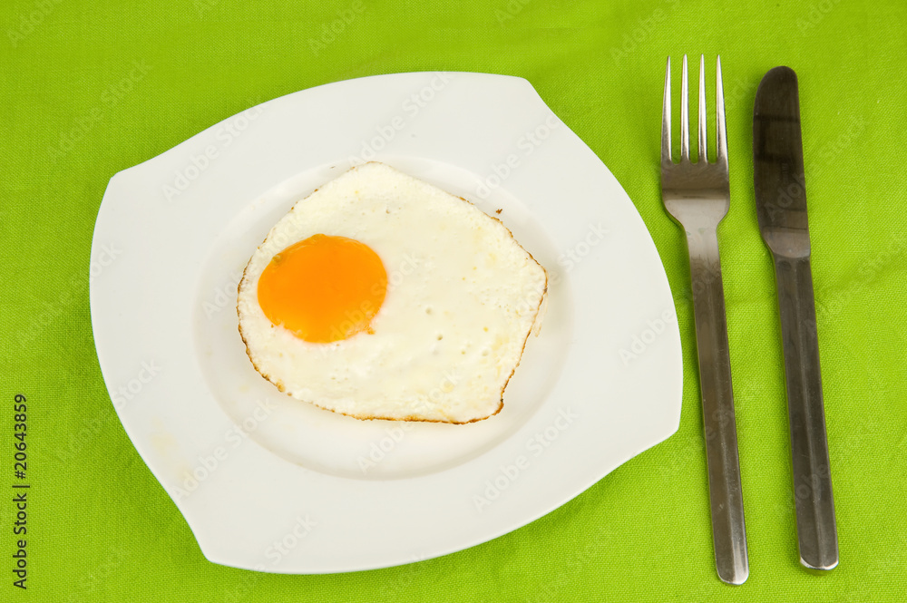 fried egg on a plate with a knife and a fork fried egg on a plate with a knife and a fork
