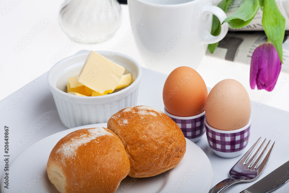 Eier, Brötchen, Butter und Kaffee auf weißem Hintergrund
