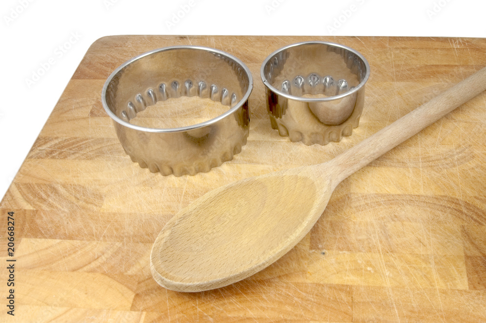 cookie cutters and wooden spoon on chopping board cookie cutters and wooden spoon on chopping board