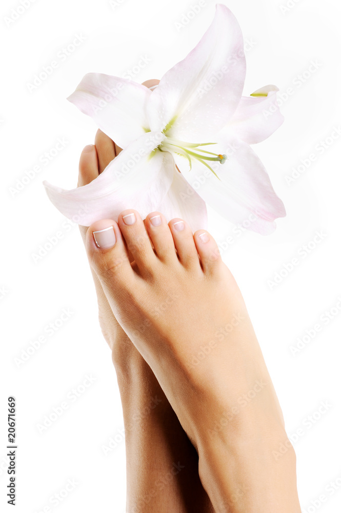 Beautiful healthy female feet with lily flowers Beautiful healthy female feet with lily flowers
