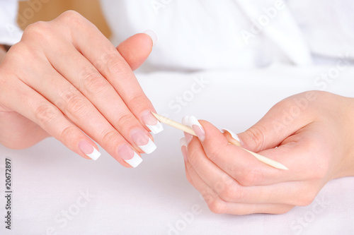 Female removing cuticle from fingers