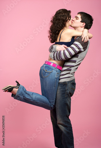 Young couple kissing over pink photo