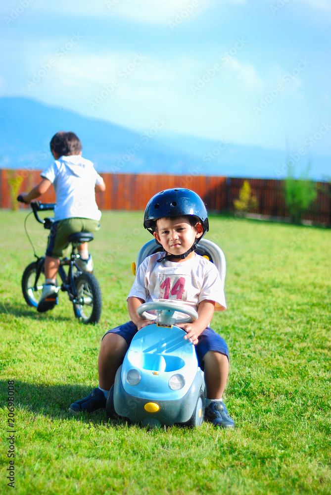 two kids are playing with toy trucks in the park two kids are playing with toy trucks in the park
