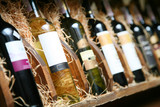 Closeup shot of wineshelf. Bottles lay over straw.