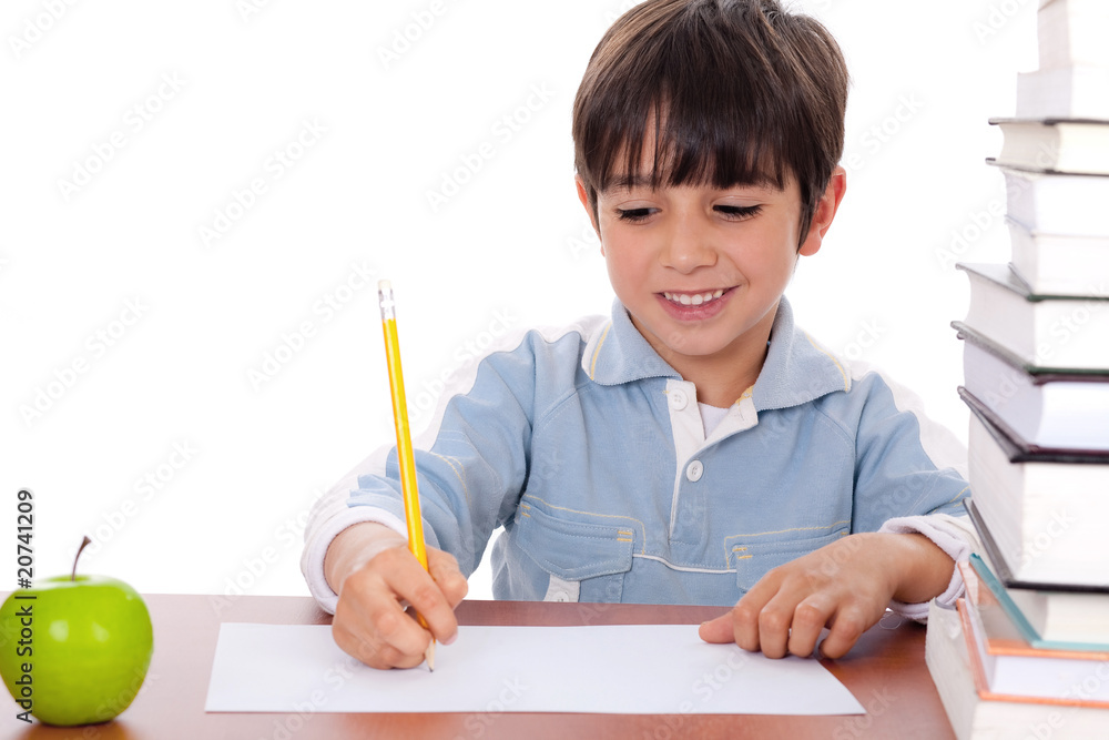 School boy doing his homework with an apple beside him School boy doing his homework with an apple beside him