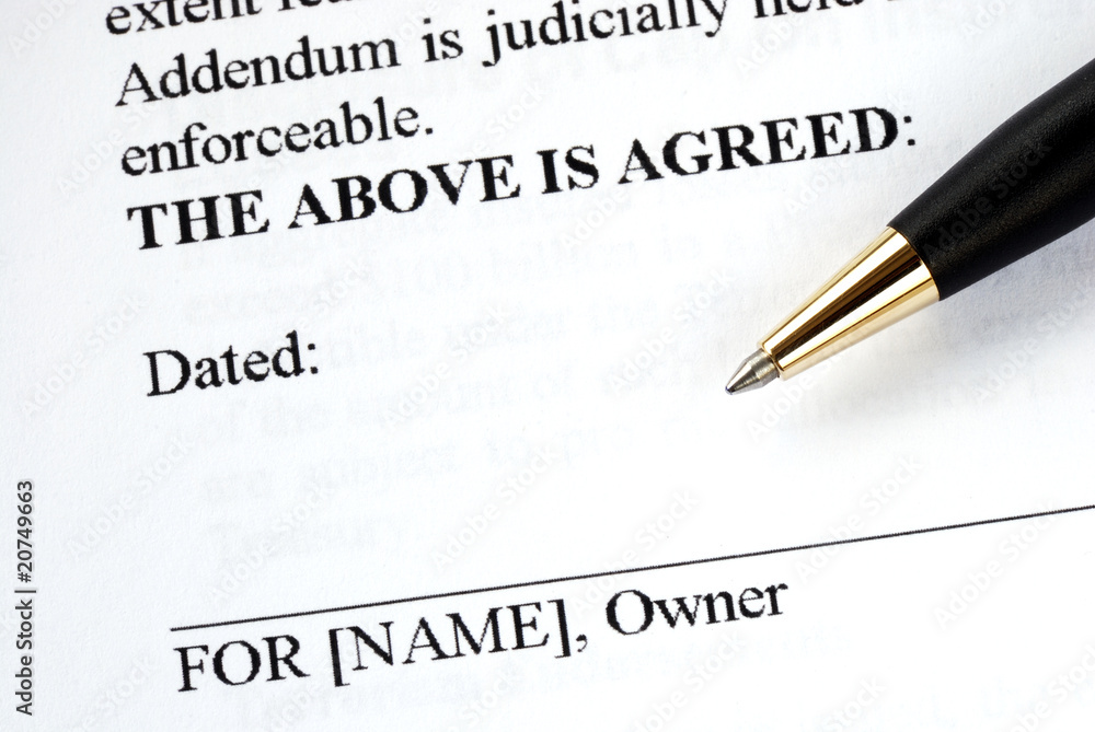 The owner signs the legal document with a pen The owner signs the legal document with a pen
